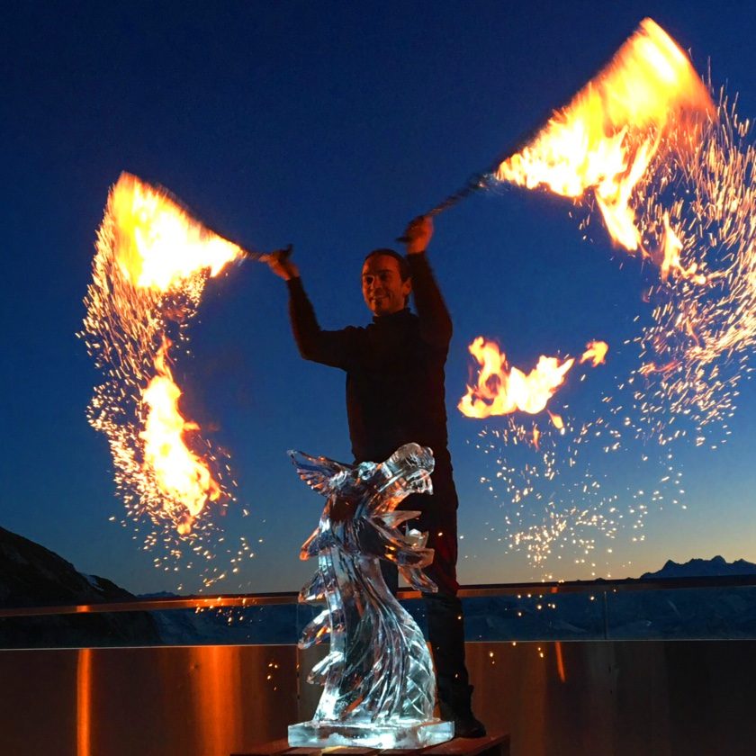 Eis-Show mit Feuer neben einer Eis-Skulptur am See