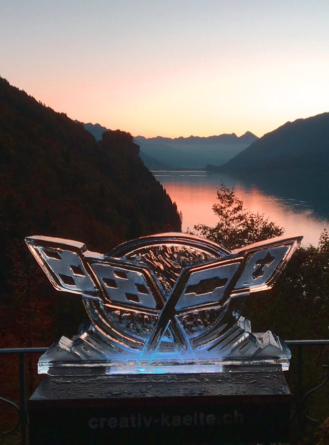 Eis-Skulptur mit Logo vor Seepanorama bei Sonnenuntergang