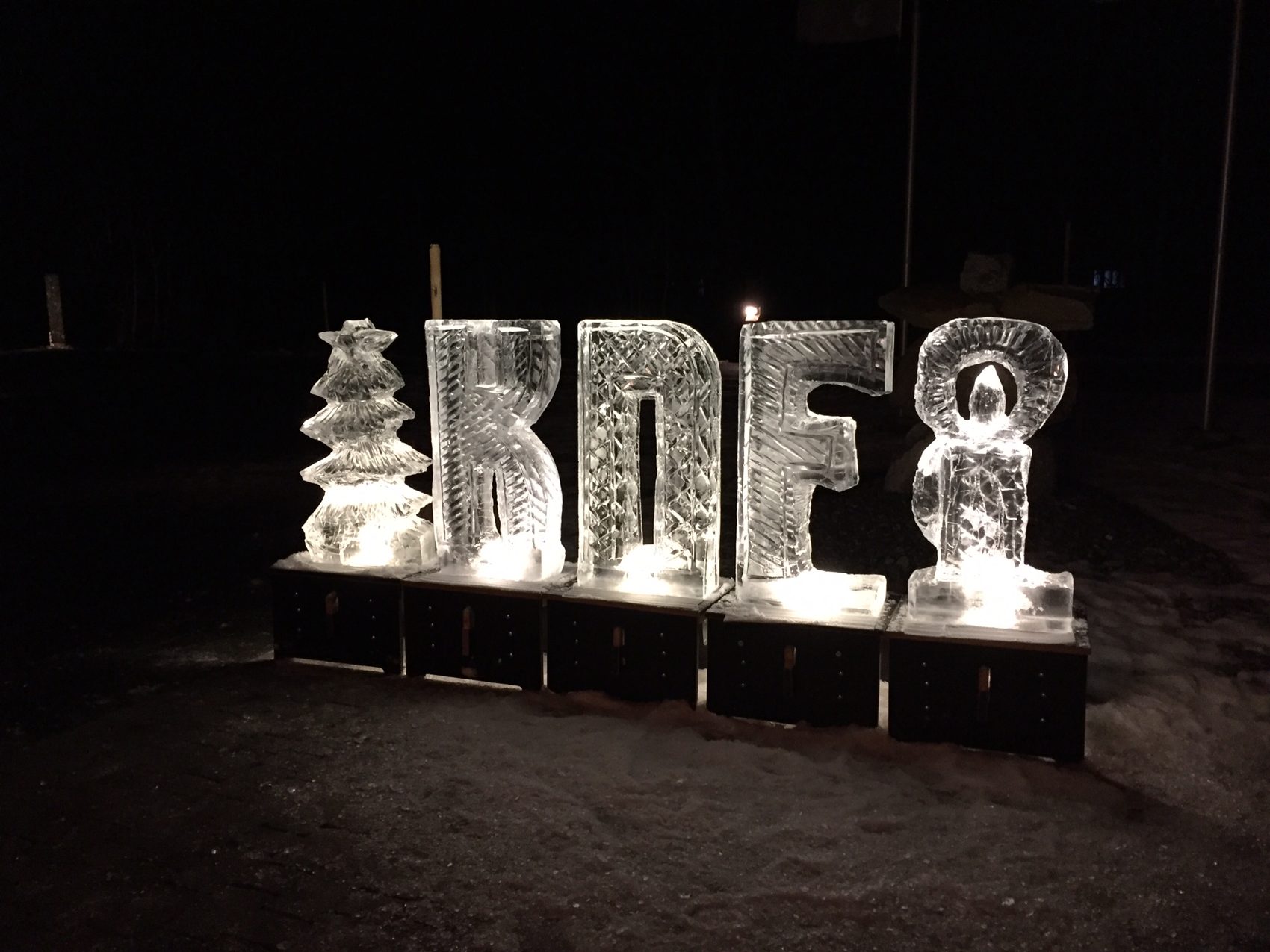 Beleuchtete Buchstaben aus Eis bei Nacht